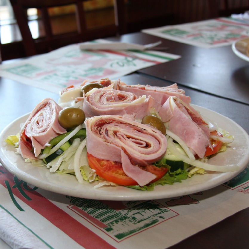 Italian salad topped with rolled deli meats